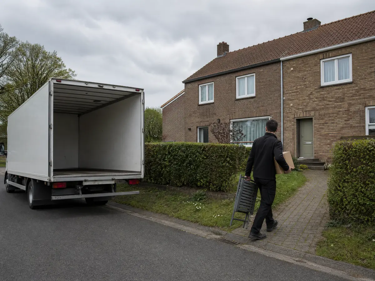 Box truck at a semi-detached house in a Genk garden district during a house clearance
