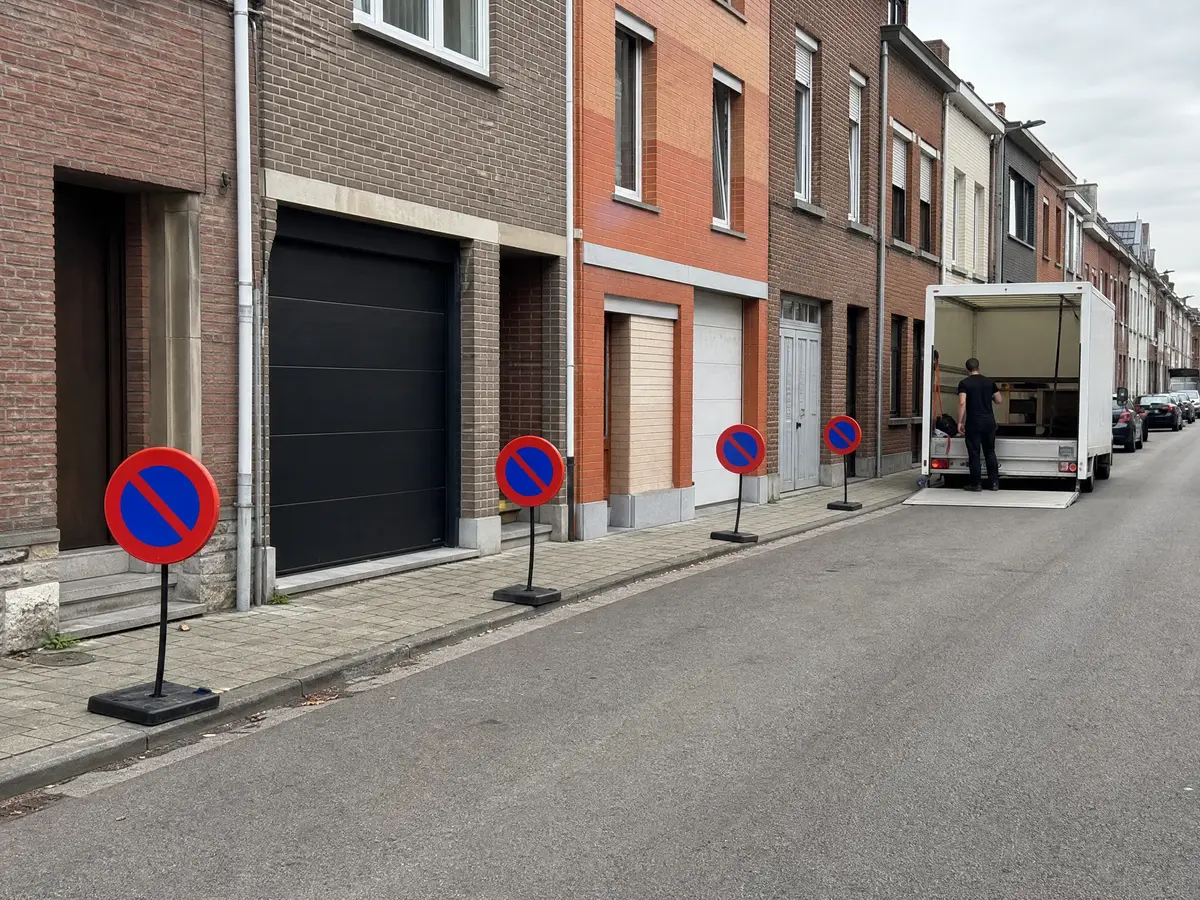 Temporary no-parking signs keep a loading bay free in front of a townhouse for a house clearance truck