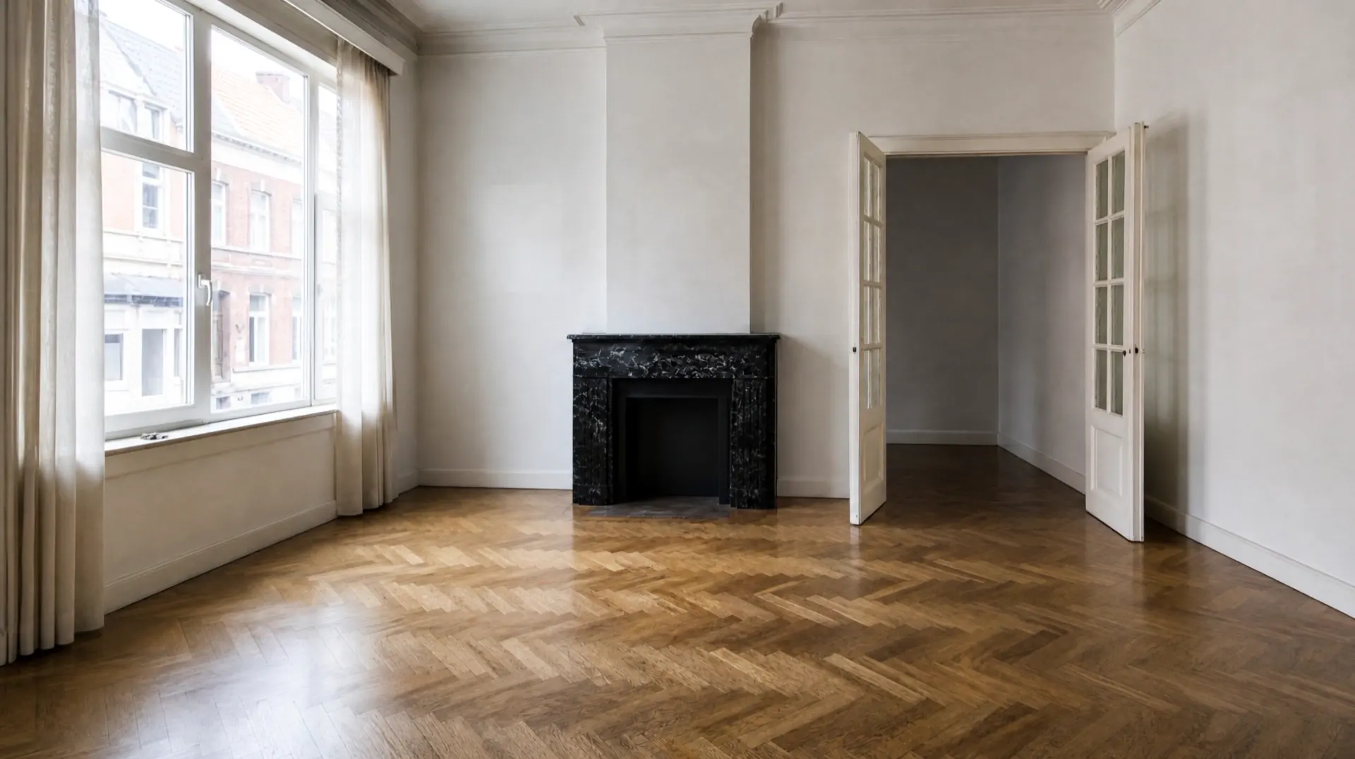 The same living room after the house clearance: empty, swept herringbone parquet and sunlight on the floor